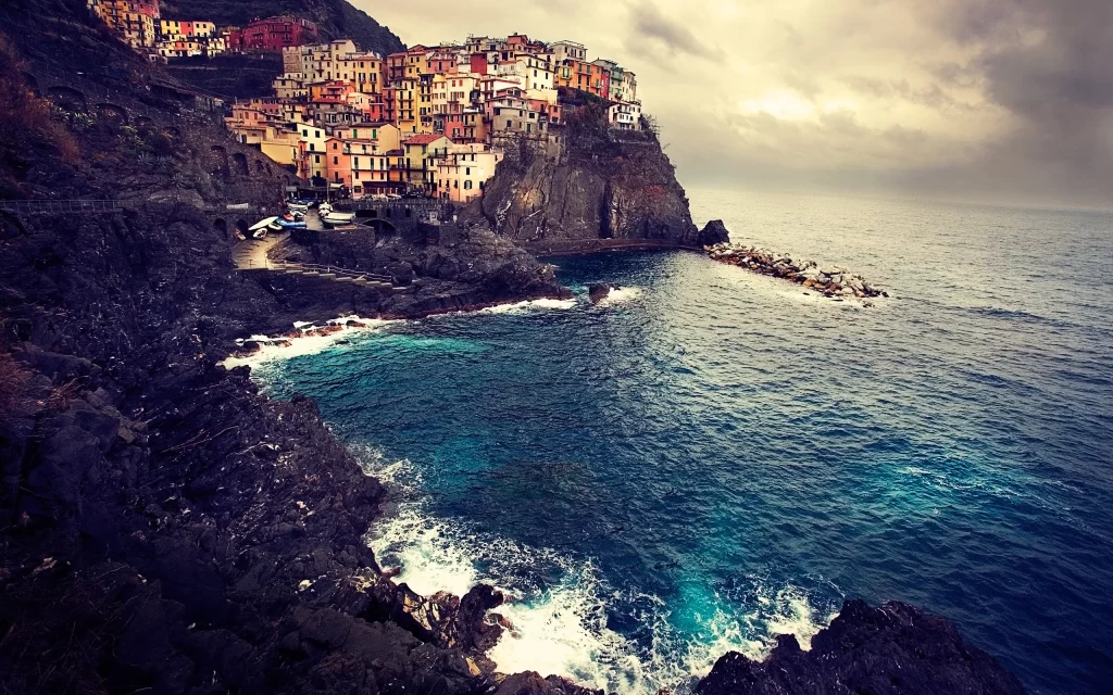 Coastal Village Cliffside Colorful Houses Ocean Waves Rocky Shore