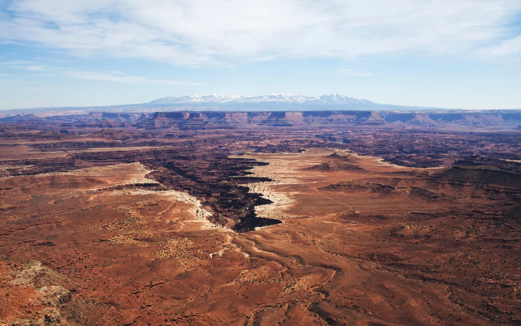 Desert Canyon Rocky Terrain Snow-Capped Mountains Blue Sky