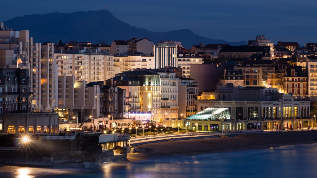 Cityscape night lights buildings beach mountains