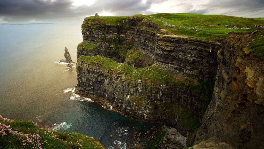 Cliffs ocean green grass sky clouds