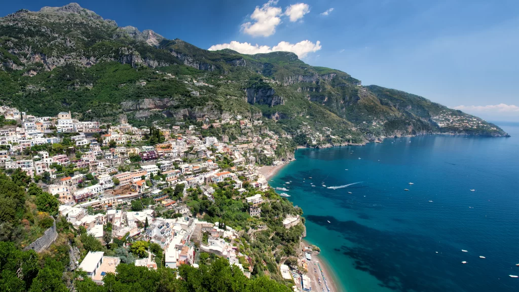Coastline buildings sea mountains sky boats