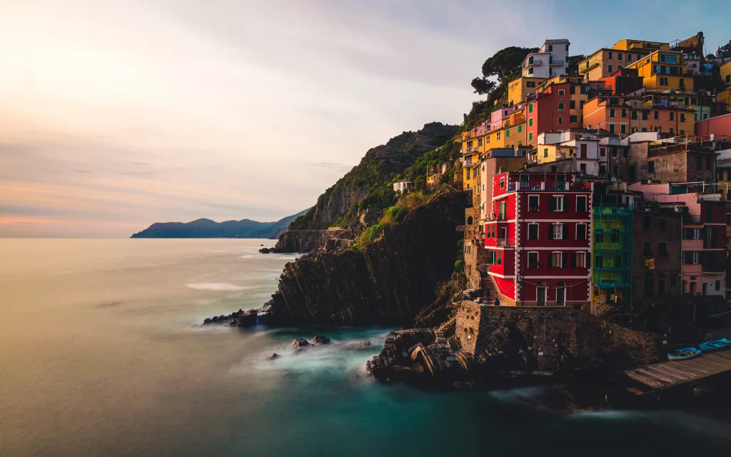Colorful Houses Coastal Town Rocky Shoreline Sunset Sea Mountains