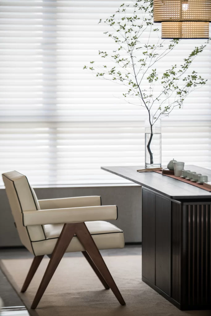 Modern minimalist room with cream-colored chair and dark wood table.