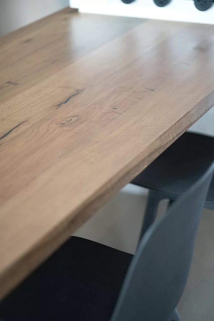 Modern minimalist room wooden table black chairs neutral tones.