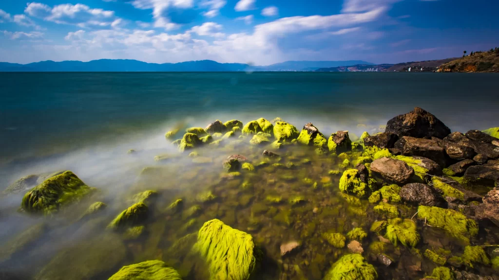 Mossy Rocks Calm Water Mountains Blue Sky Clouds