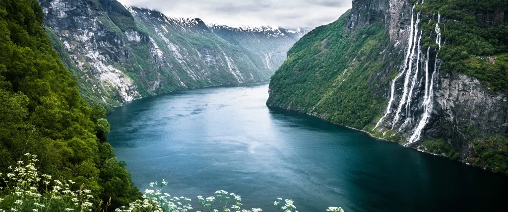 Narrow Fjord Steep Cliffs Lush Greenery Waterfalls Serene Misty