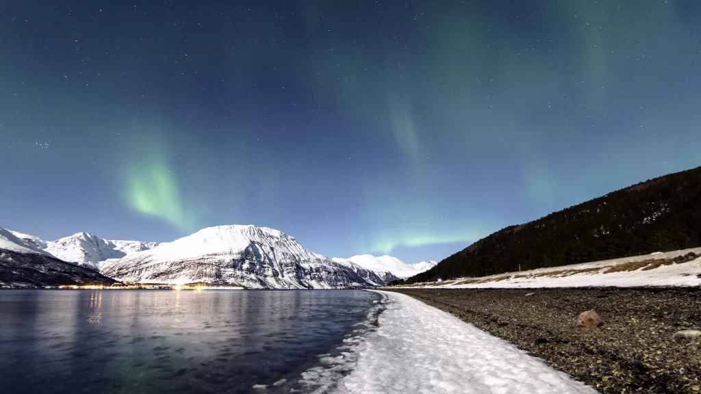 Northern lights snow mountains lake night reflection