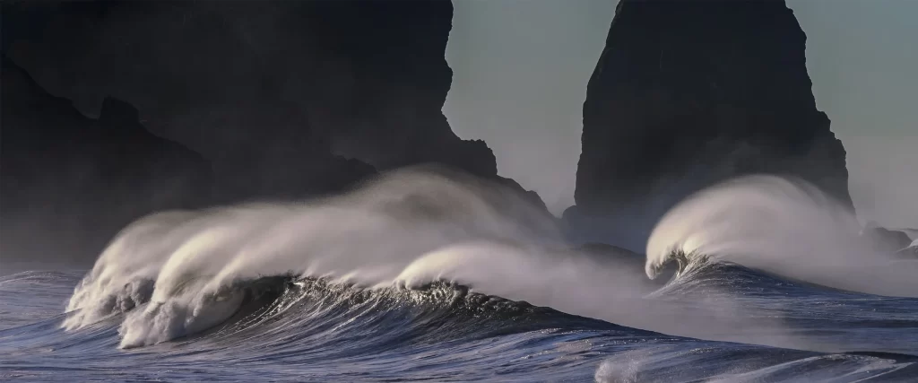 Ocean Waves Rocky Cliffs Dramatic Lighting Dynamic Motion Natural Beauty Serene Atmosphere