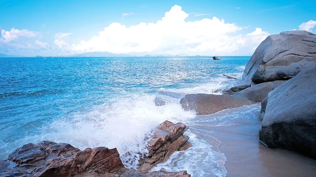 Ocean waves rocky shore blue sky clouds