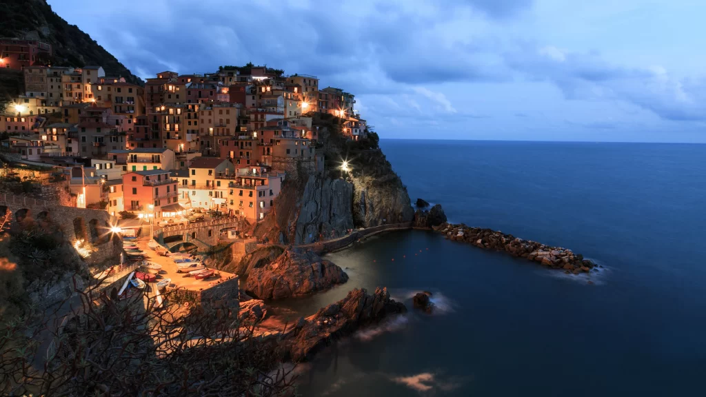 Sea sky buildings lights dusk cliffs