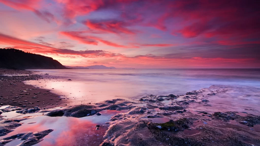 Sunset beach ocean rocks sky clouds