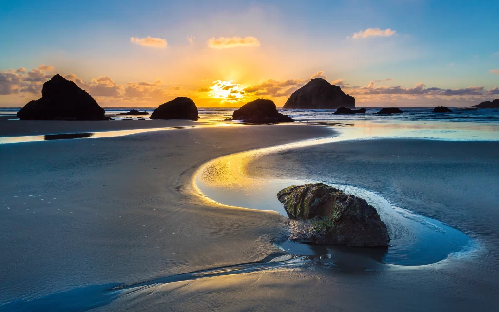 Sunset beach rocks water sky clouds