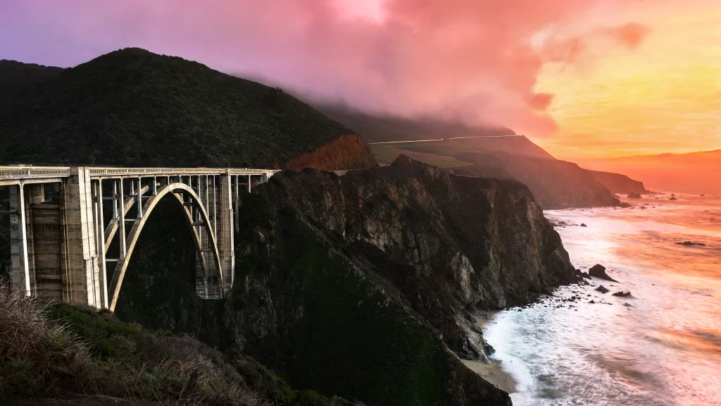 Sunset bridge ocean cliffs landscape sky
