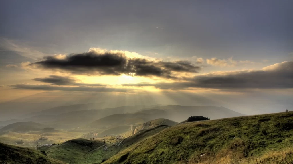 Sunset landscape hills clouds rays nature