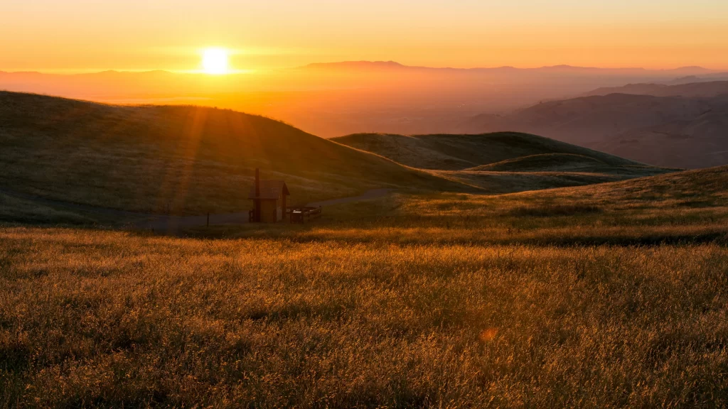 Sunset landscape hills grass sky tranquility