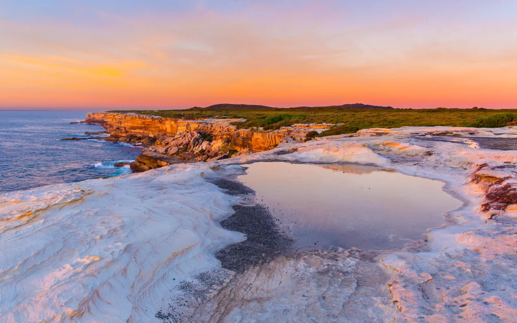 Sunset ocean cliffs rock pool landscape sky