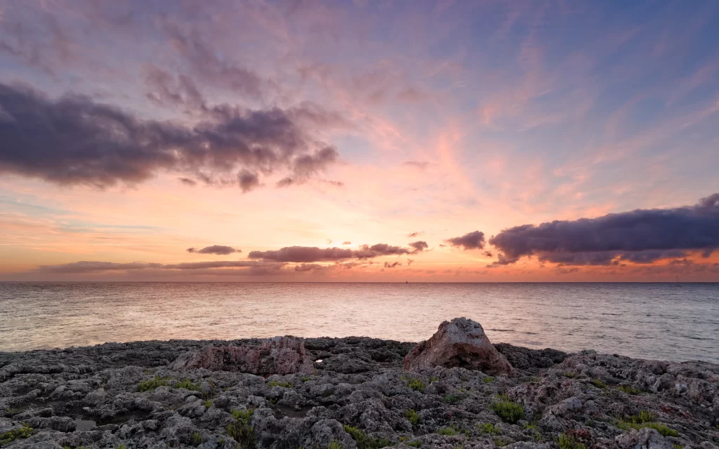 Sunset ocean clouds rocks horizon sky