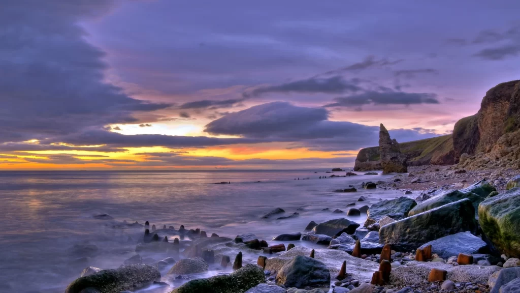 Sunset ocean rocks clouds cliffs sky