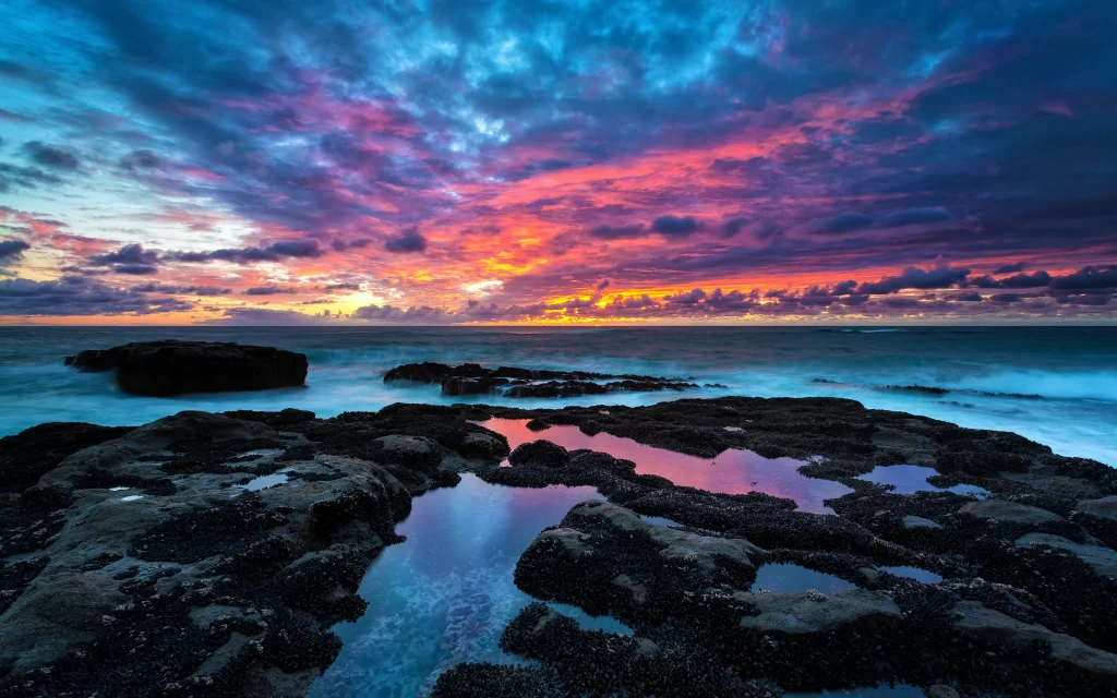 Sunset ocean rocks clouds reflection colors
