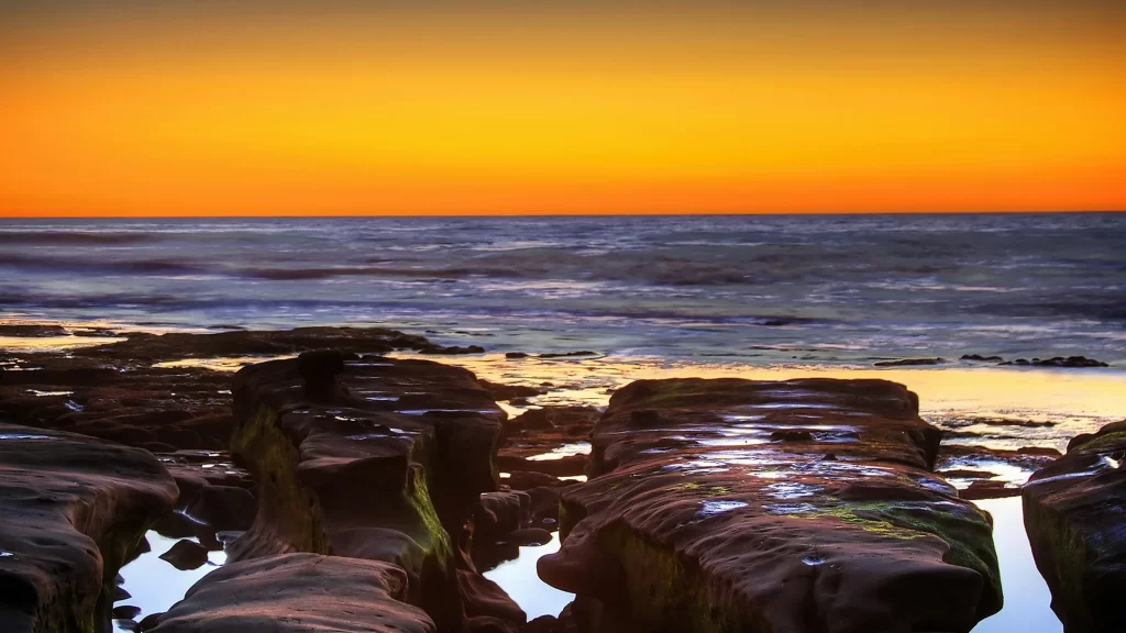 Sunset ocean rocks horizon reflection colors