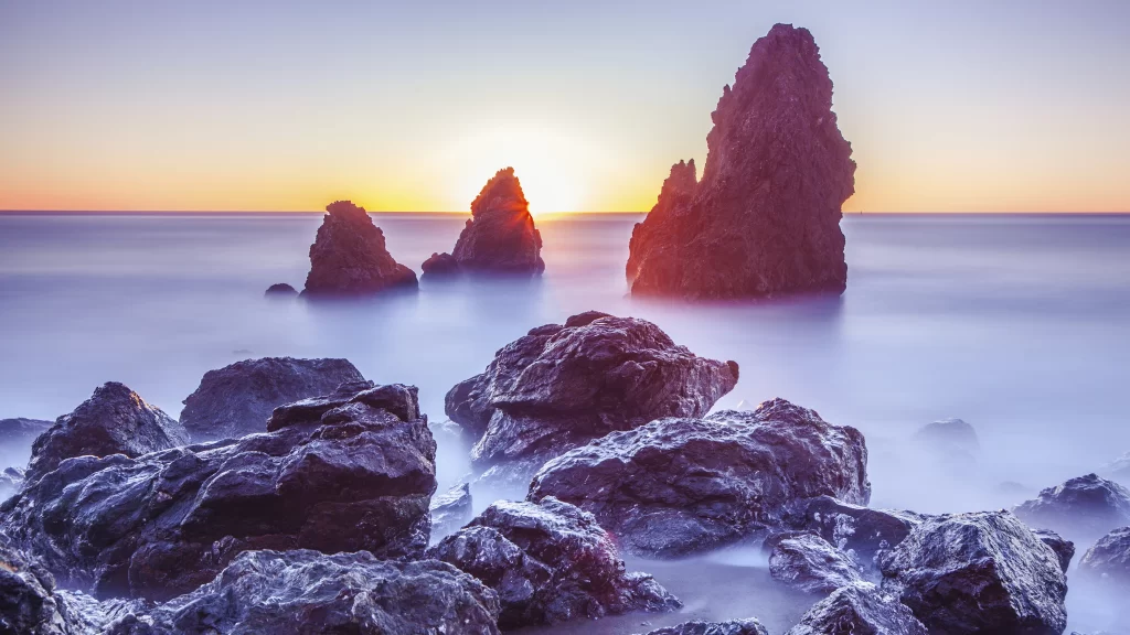 Sunset ocean rocks horizon sky waves
