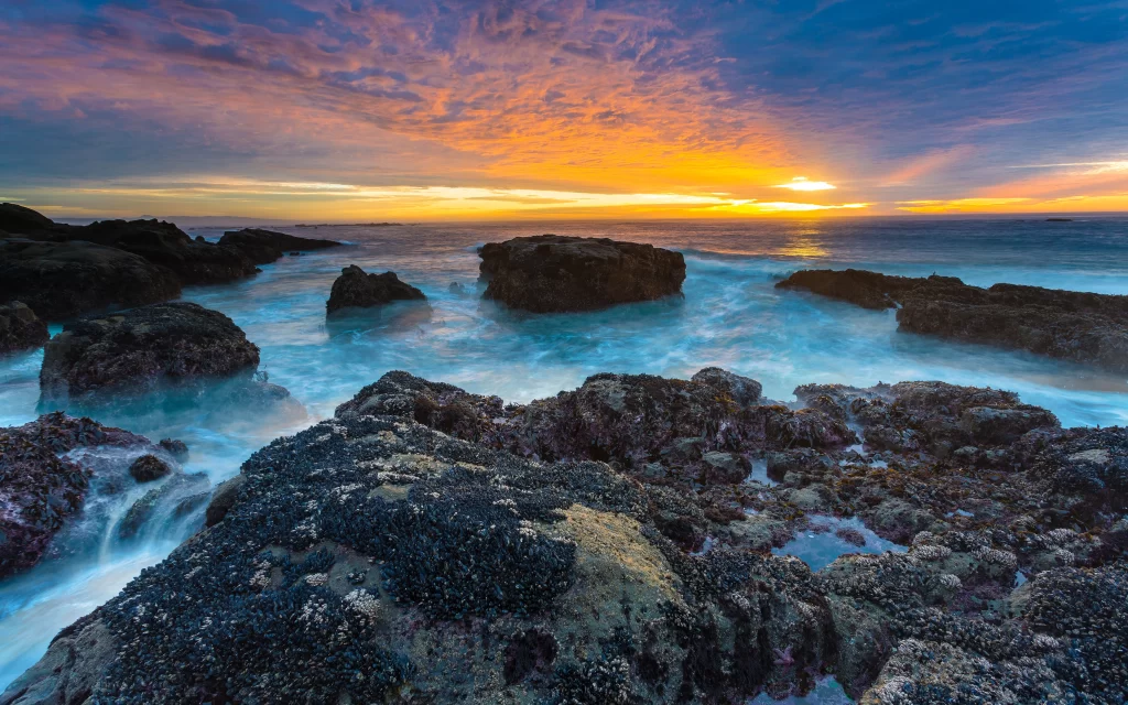 Sunset ocean rocks waves sky clouds