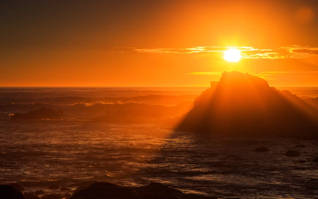 Sunset ocean waves rock sky clouds horizon glow