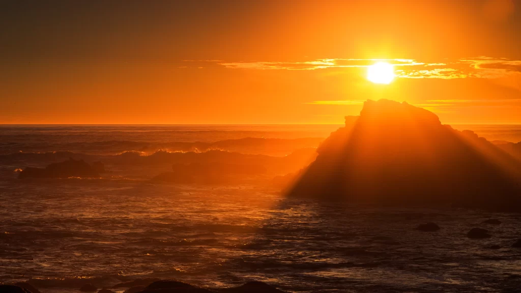 Sunset ocean waves rock sky clouds horizon glow
