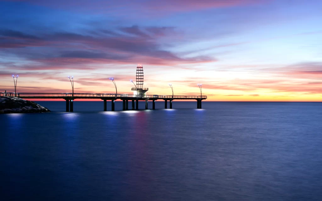 Sunset pier ocean sky clouds lights