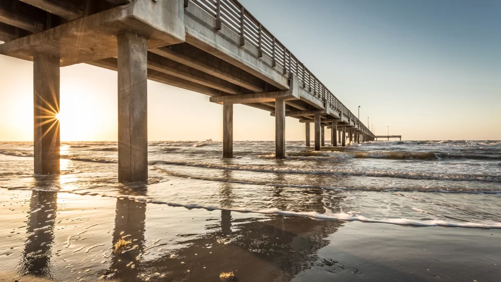 Sunset pier ocean waves reflection sky