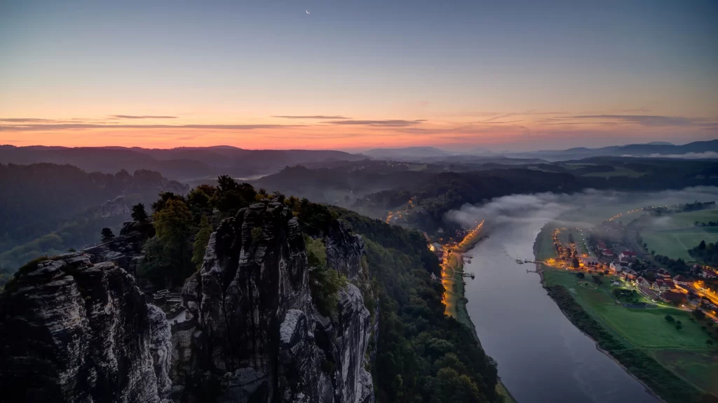 Sunset river landscape mist cliffs village