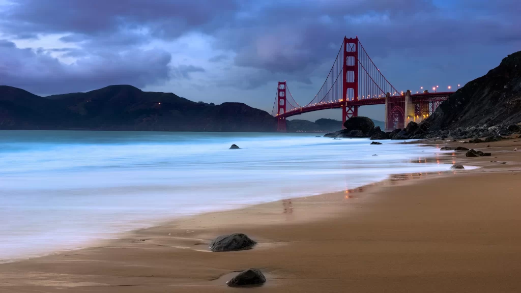beach bridge ocean waves sky clouds
