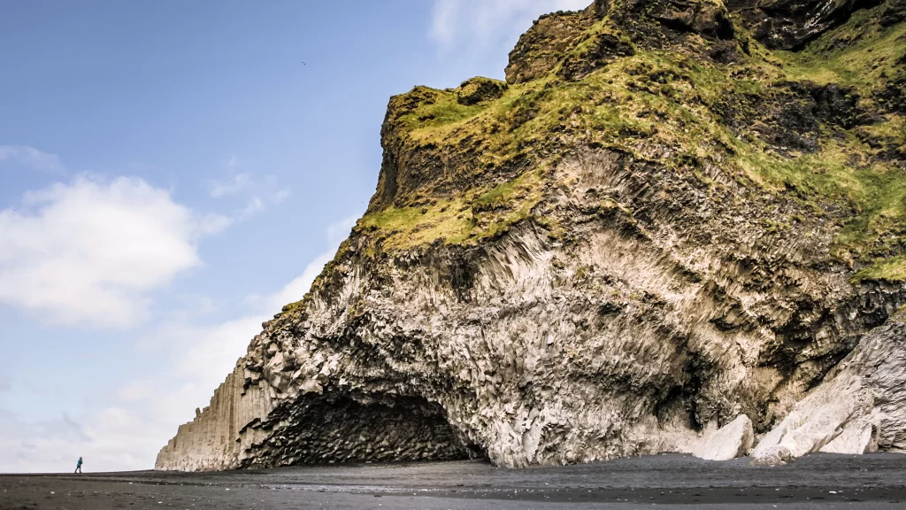 beach cliff grass sky clouds rock
