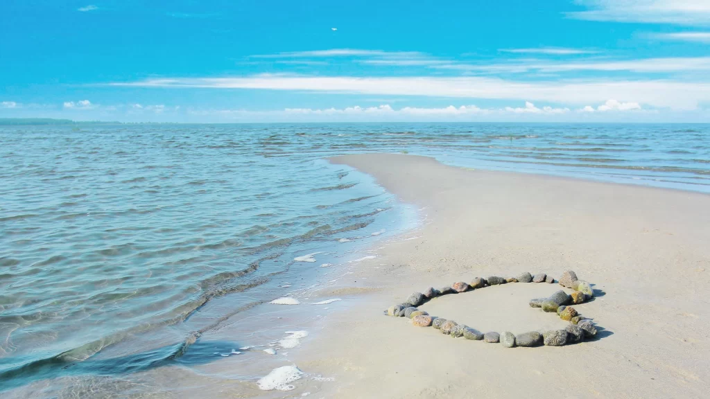 beach heart stones ocean sky clouds