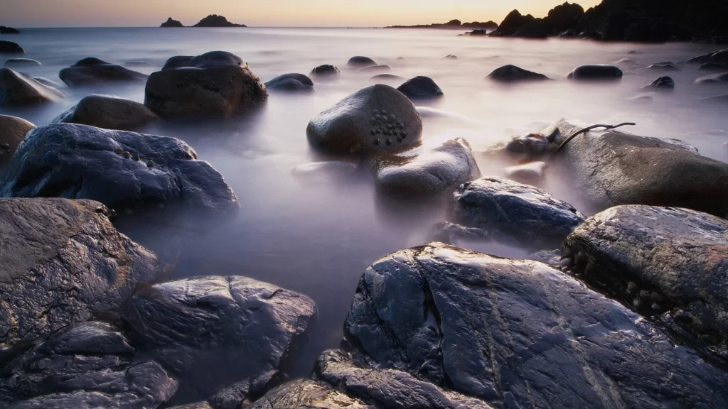 beach rocks water sunset sky