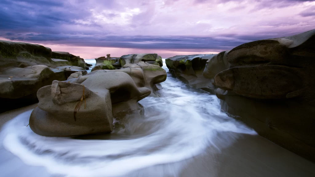 beach rocks waves sky clouds