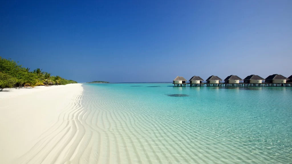 beach water sky huts sand ocean
