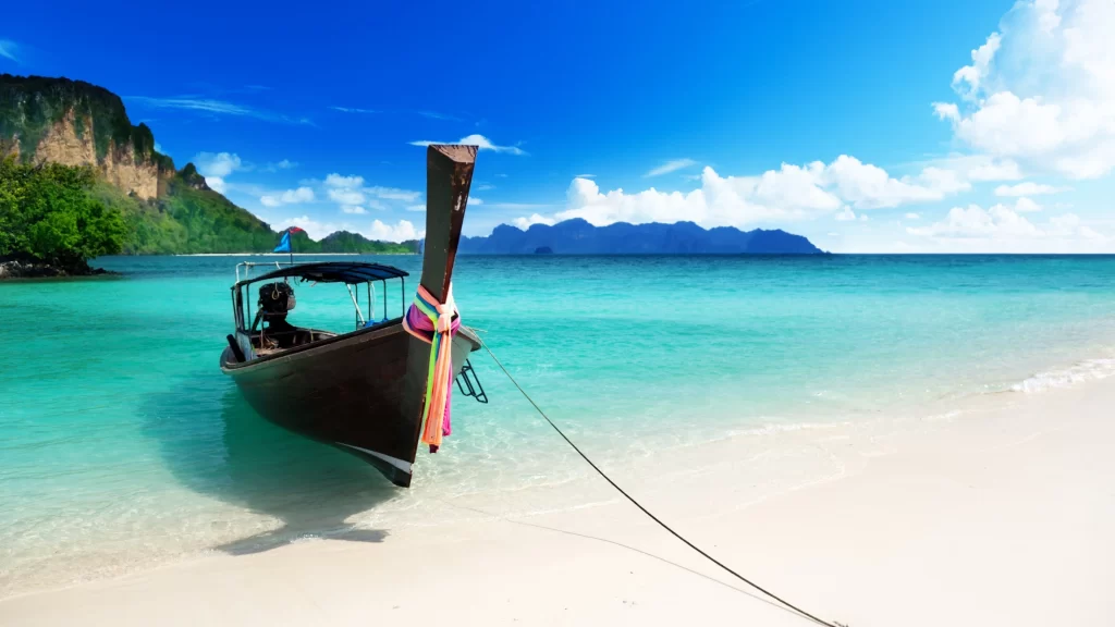 boat beach sea sky mountains clouds