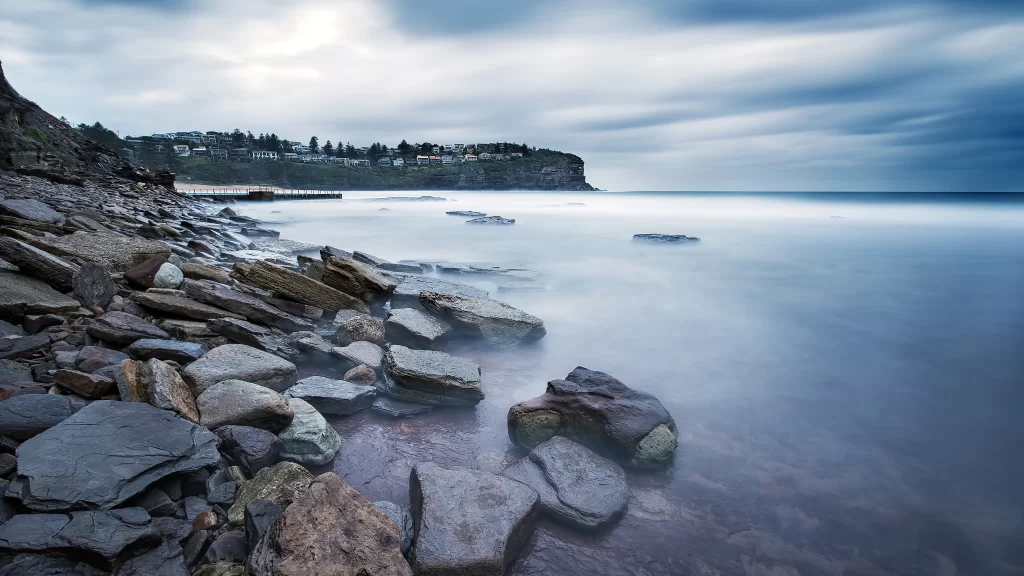 calm ocean rocky shore misty clouds tranquil