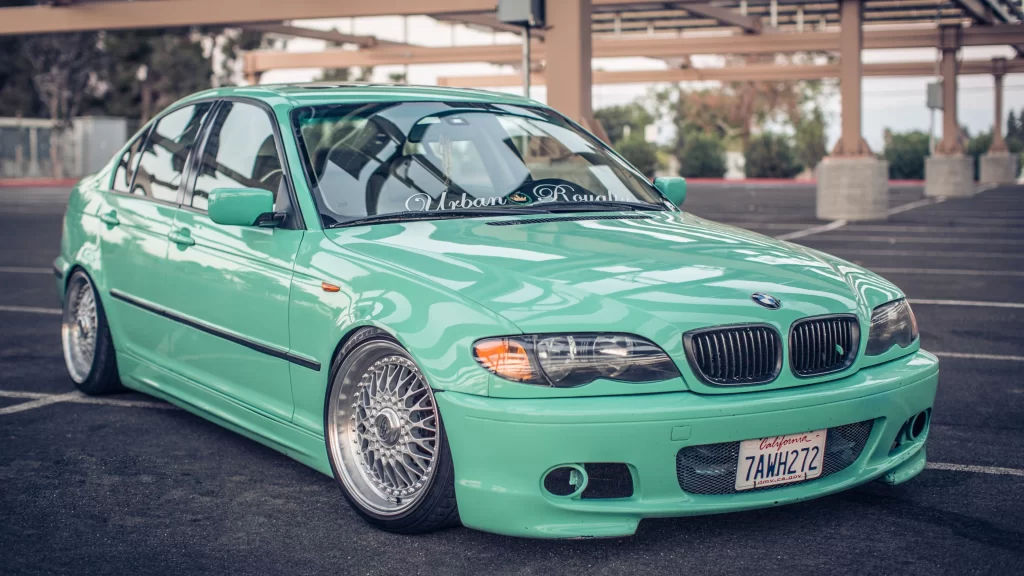 car mint green BMW parking lot wheels license plate