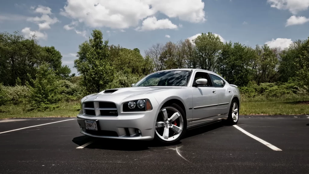 car silver parking lot trees sky clouds