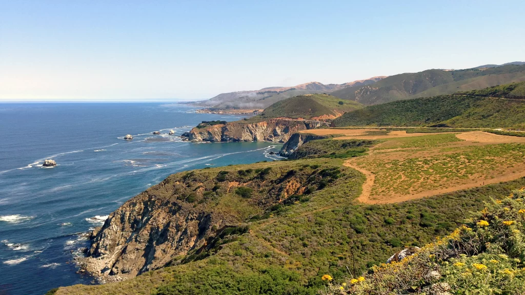 coastal landscape cliffs ocean greenery vineyard clear sky