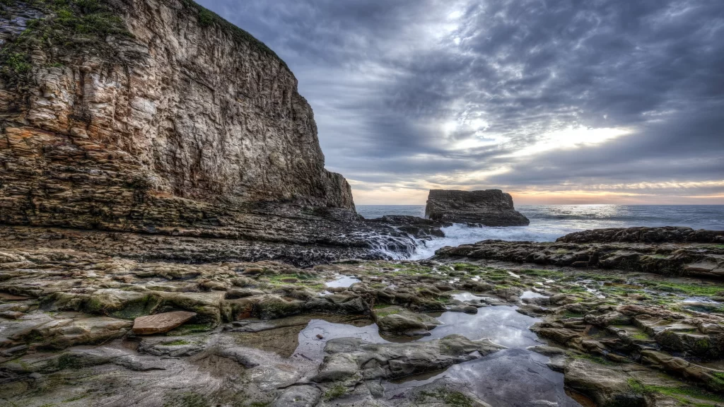 coastal landscape rocky cliffs ocean waves dramatic sky
