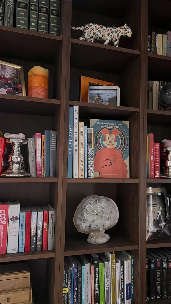 Dark Wooden Bookshelf with Multilingual Books and Ceramic Leopard