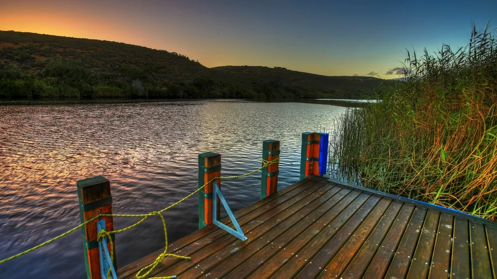 dock lake sunset reeds mountains sky
