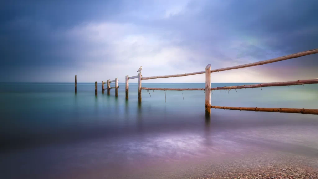 fence water sky clouds horizon reflection