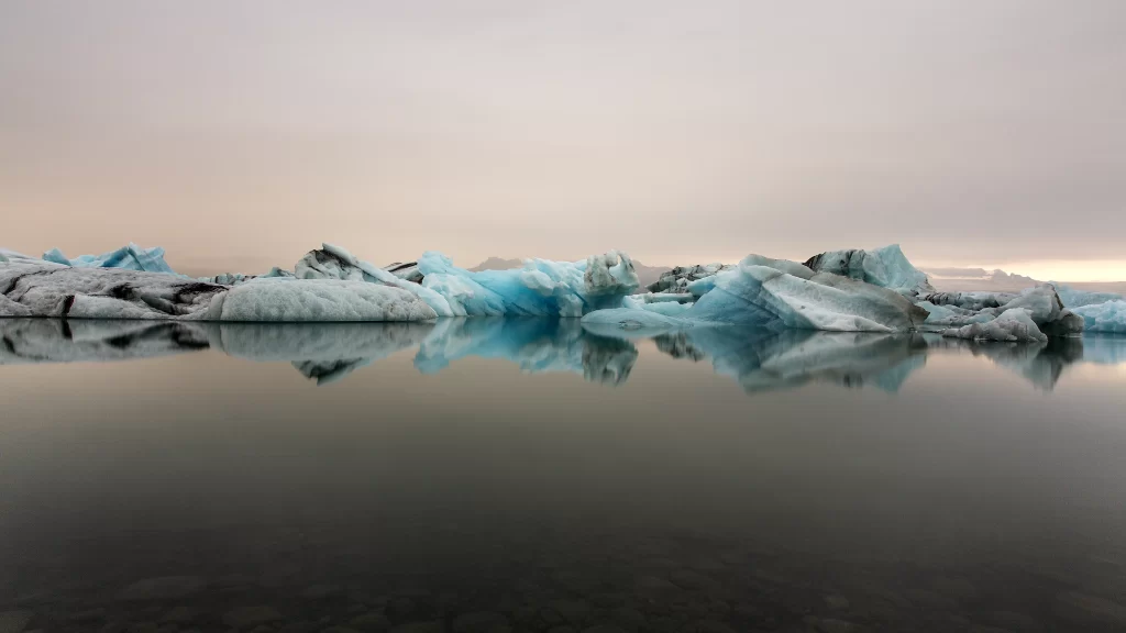 icebergs reflection calm water sky clouds natural beauty