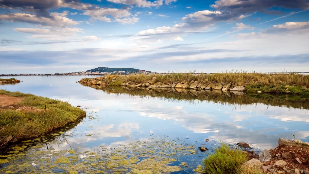 lake sky clouds reflection grass rocks