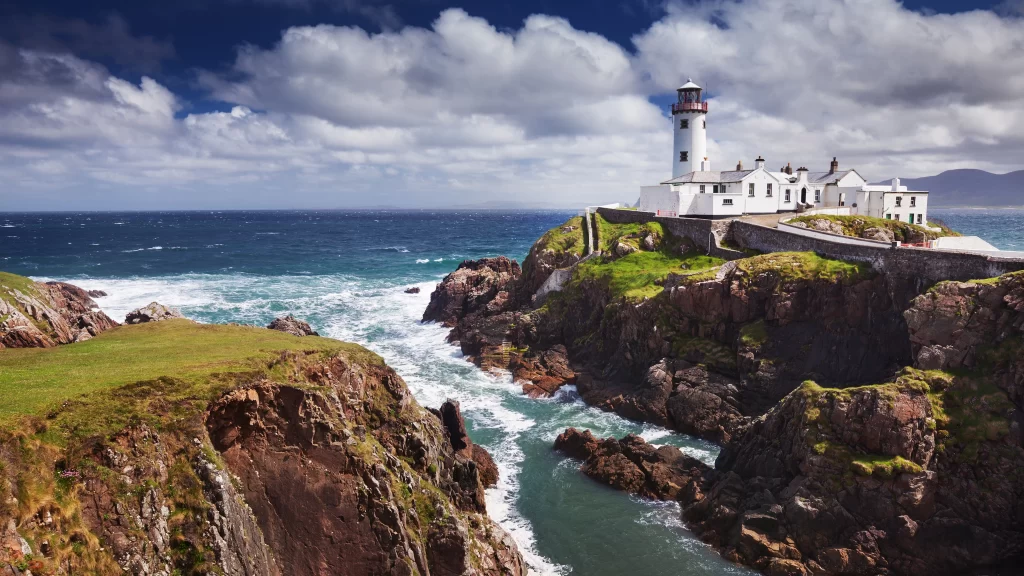 lighthouse ocean cliffs waves clouds landscape