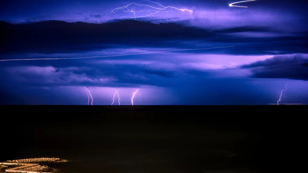lightning storm clouds night sky horizon sea reflection